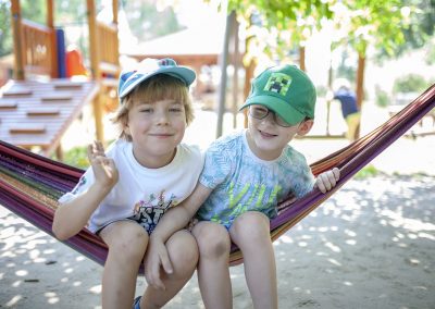 Rekrutacja. Uśmiechnięci chłopcy na placu zabaw przedszkola Róża Montessori w Warszawie Białołęce